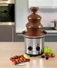 A chocolate fountain with fruit skewers and grapes on a kitchen counter. Podgląd zdjęcia produktu