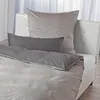 A bed with bedding, including a large pillow and a long bolster pillow. Produktbild-Vorschau