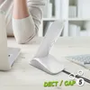 A person's arm is resting on a desk next to a white wireless phone and a laptop. Anteprima dell’immagine prodotto