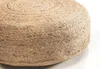 A close-up view of a round, woven pouf made of jute. Produktbild-Vorschau