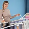 A woman is shown adjusting a foldable drying rack with clothes on it. Náhled obrázku produktu