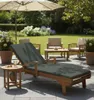 A patio scene with outdoor furniture, including a chaise lounge and chairs, set on a paved patio with a garden in the background. Produktbild-Vorschau