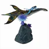 A toy figurine of a character riding a winged creature, displayed on a rocky base with alien flora. Produktbild-Vorschau