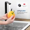 A person is washing a yellow bell pepper under a black kitchen faucet. The image also includes a close-up of a faucet aerator and text describing its features. Produktbild-Vorschau