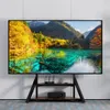 A TV stand with a large screen displaying a scenic landscape, placed against a white wall. Produktbild-Vorschau