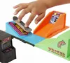 A child's hand is shown playing with a Hot Wheels skate track set, which includes an arcade machine, ramps, and a scoreboard. Produktbild-Vorschau