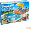 A Playmobil swimming pool playset on its packaging, showing a scene with figures enjoying the pool and deck area. Voir les images du produit