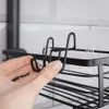 A hand is holding a black metal shower caddy hook. Náhled obrázku produktu