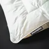 A close-up of a white duvet with a black label. Produktbild-Vorschau