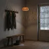 A cozy entryway with a wooden bench, coat rack, and a door with snow falling outside. Produktbild-Vorschau