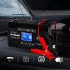 A car battery charger is shown in the engine bay of a car with the hood open. Náhled obrázku produktu
