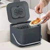 A person is shown discarding food scraps into a compost bin in a kitchen setting. Produktbild-Vorschau