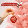 A hand is holding a red Christmas ornament with a snowflake design, about to hang it on a pink artificial Christmas tree. A small Santa Claus decoration is hanging on the tree. Anteprima dell’immagine prodotto