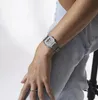 A person wearing a watch and jeans. Produktbild-Vorschau