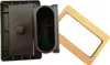 A black plastic sink overflow part and a brown cardboard frame are shown against a white background. Produktbild-Vorschau