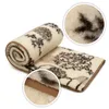 A rolled-up blanket with a floral pattern and a close-up view of the texture and edge. Produktbild-Vorschau