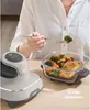 A person is shown eating from a glass container next to a Ninja CRISPI air fryer. Anteprima dell’immagine prodotto