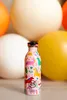 A pink water bottle with a unicorn pattern is displayed in front of large, out-of-focus spheres of various colors. Voir les images du produit