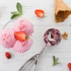 A top-down view of strawberry ice cream in a bowl with a scoop and scattered strawberries and mint leaves on a white wooden surface. Náhľad obrázku produktu