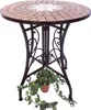 A round mosaic table with a star pattern on top, supported by a dark metal base, with a potted plant hanging underneath. Produktbild-Vorschau