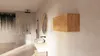 A modern bathroom with a hanging cabinet, sink, mirror, and plants. Produktbild-Vorschau