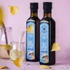 Two bottles of oil with labels, surrounded by autumn leaves and a glass of lemon water. Produktbild-Vorschau