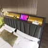A modern bedroom with a bed featuring a headboard with integrated LED lighting and charging capabilities. Voir les images du produit