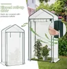 A greenhouse with plants inside, shown in a garden setting with a house in the background. Produktbild-Vorschau