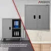 Two grey metal cabinets are shown, one on wheels on the floor and one mounted on a wall. The one on the floor has its door open, revealing shelves with binders. The wall-mounted cabinet is closed. Produktbild-Vorschau