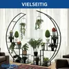 A modern, circular metal plant stand filled with various artificial plants, displayed indoors in front of a window with sheer curtains. Anteprima dell’immagine prodotto