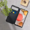 A smartphone with a flip case, a credit card, and a plant on a textured surface. Náhled obrázku produktu