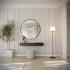 A modern entryway with a round mirror, a console table, a plant, and a floor lamp. Náhled obrázku produktu