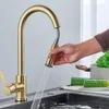 A hand is holding a pull-down kitchen faucet spray head, with water spraying into a sink. Cucumbers and a pot are visible on the counter. Produktbild-Vorschau