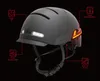 A black bicycle helmet with integrated lights and warning labels pointing to its features. Náhled obrázku produktu