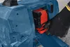 A gloved hand is inserting a battery into a blue power tool. Produktbild-Vorschau