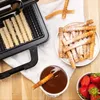 A waffle maker is shown with freshly made waffle fries, a bowl of chocolate dip, and strawberries. Podgląd zdjęcia produktu