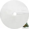 A white, fluffy Christmas tree skirt with a hole in the center for the tree trunk. A small, decorated Christmas tree is visible in the bottom right corner. Produktbild-Vorschau