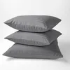 Three dark gray striped pillows are stacked on a white background. Produktbild-Vorschau