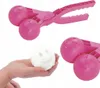 A pink snowball maker is shown with a snowball that has a smiley face pressed into it. The snowball is being held in a person's hand. Podgląd zdjęcia produktu
