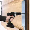 A person is using a cordless drill to screw a metal plate onto a wooden surface. Produktbild-Vorschau