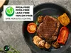 A close-up overhead view of a frying pan with a steak and vegetables, with a marketing overlay highlighting product features. Produktbild-Vorschau