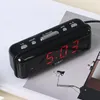 A black digital alarm clock with red LED display is shown on a white and gray surface. Produktbild-Vorschau