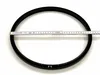A black ring is placed on a white background with a measuring tape across it. Produktbild-Vorschau