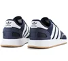 A pair of navy blue Adidas sneakers with white stripes and soles, shown from a rear-side angle against a white background. Podgląd zdjęcia produktu