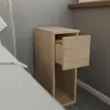 A narrow wooden nightstand with an open drawer next to a bed. Produktbild-Vorschau