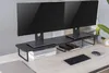 A black monitor stand for two monitors is shown on a desk with two monitors on top. There are also books, a tablet, a keyboard, and a mouse on the desk. Náhled obrázku produktu