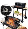 A charcoal grill with a rotisserie and food, set against a white background, with a close-up inset of the rotisserie mechanism. Produktbild-Vorschau