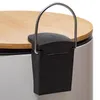 A close-up view of the pedal mechanism and lid of a white trash can with a bamboo lid. Anteprima dell’immagine prodotto