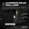 A black solar wall lamp with a motion sensor is mounted on the side of a dark-colored building at night. Produktbild-Vorschau