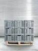 A stack of gray folding crates on a wooden pallet in front of a corrugated metal wall. Produktbild-Vorschau